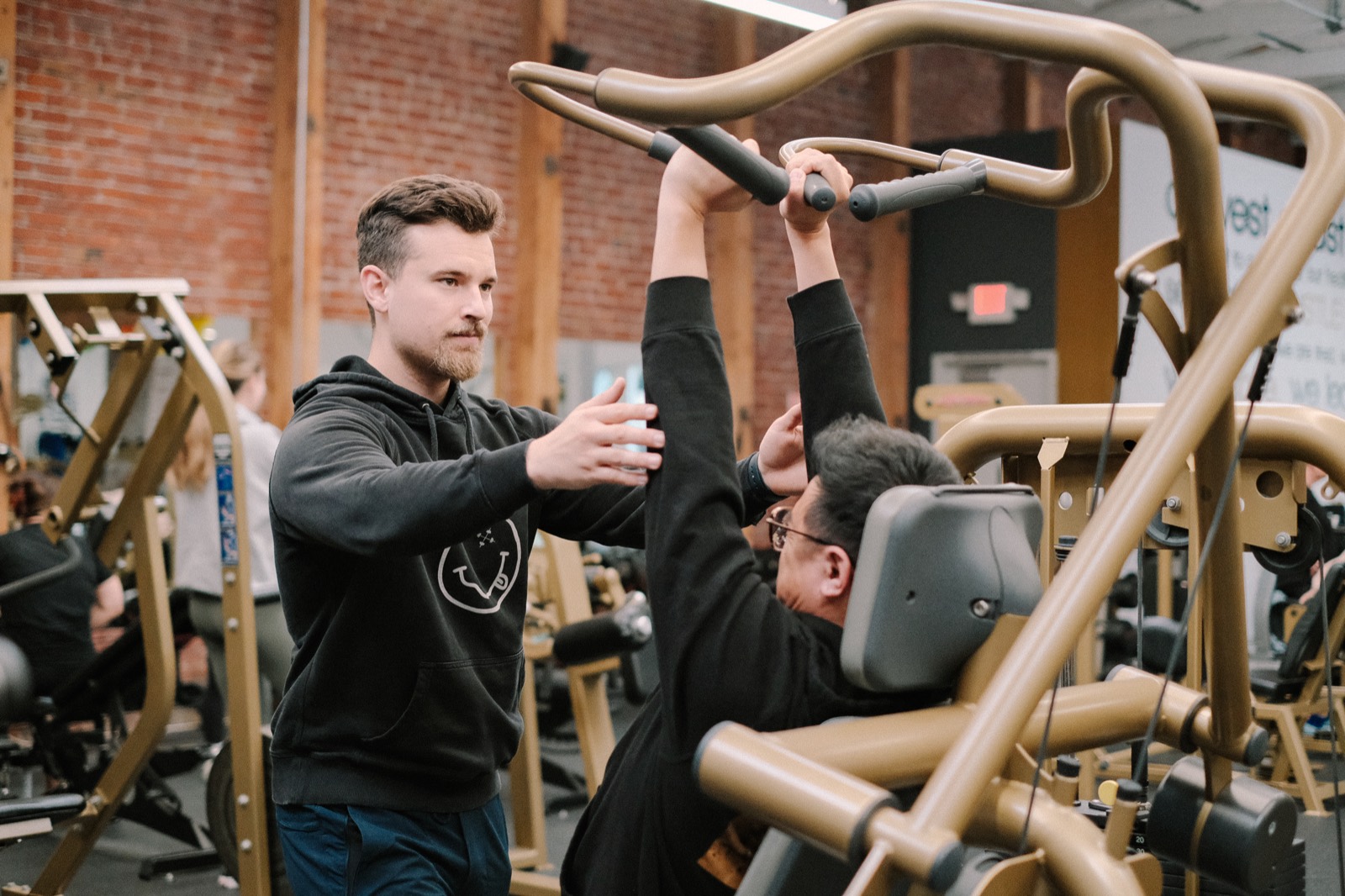 A WESTCA coach guiding a member through a machine press